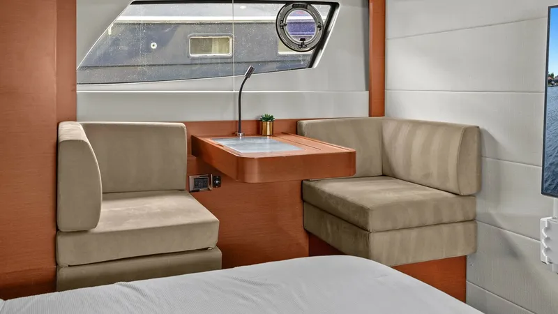 Slide: The Image of Luxurious Cabin Seating Area This inviting cabin features a cozy seating area with plush, beige upholstery, perfect for relaxation. The modern design includes a sleek wooden table, enhancing the space's functionality and elegance. Large windows allow for ample natural light, providin - 7603798
