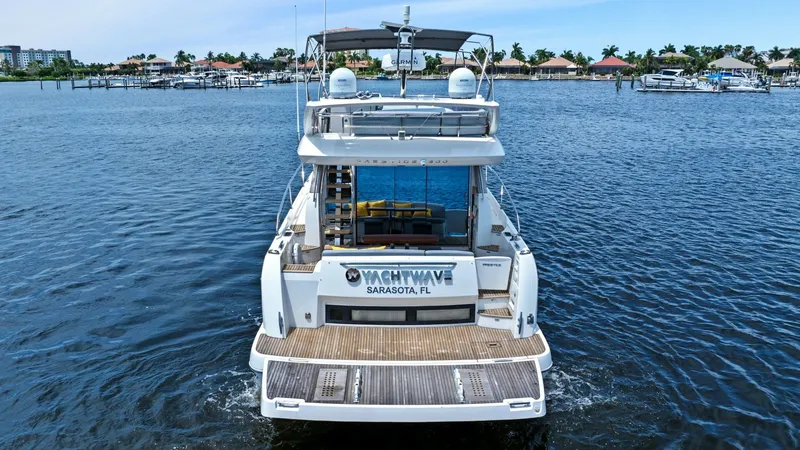 Slide: The Image of Stern View with Swim Platform This image showcases the elegant stern of the Prestige 500 Fly, featuring a spacious swim platform ideal for easy water access. The aft deck offers a seamless transition to the interior, with large glass doors providing stunning views and natural light. T - 7603835