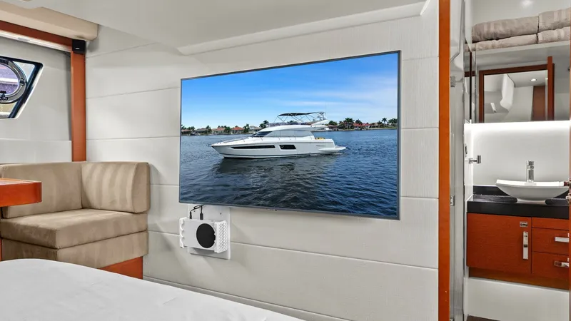 Slide: The Image of Master Stateroom with Ensuite The master stateroom of the Prestige 500 Fly features a comfortable queen-sized bed with plush seating. A wall-mounted flat-screen TV provides entertainment, while the ensuite bathroom offers sleek, modern fixtures and ample storage. The space is elegantl - 7603799