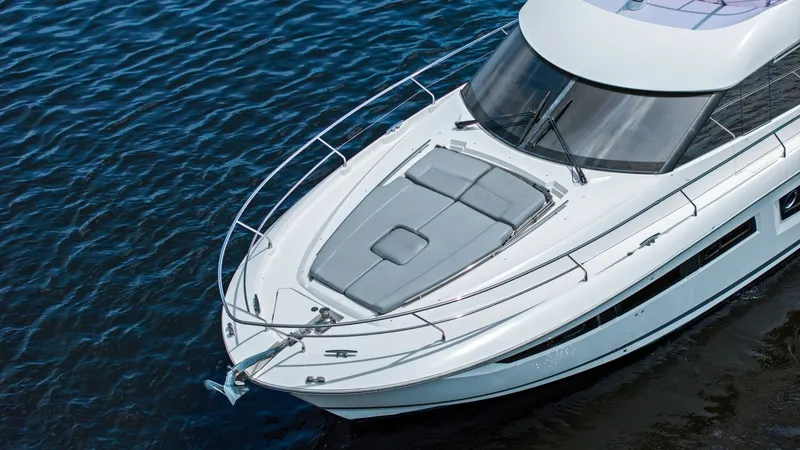 Slide: The Image of Foredeck with Sun Lounge The Prestige 500 Fly's foredeck features a spacious sun lounge, perfect for relaxation under the sun. The sleek design includes comfortable cushions and sturdy stainless-steel railings for safety. This area combines luxury and practicality, offering a pri - 7603838