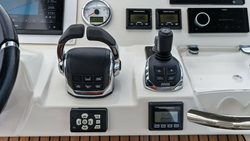 Slide: The Image of Helm Control Station Close-Up This image showcases the helm control station of the 2015 Prestige 500 Fly, featuring a sophisticated array of navigational and control instruments. The dual throttle levers and joystick provide precise maneuverability, while the digital displays ensure e - 7603763