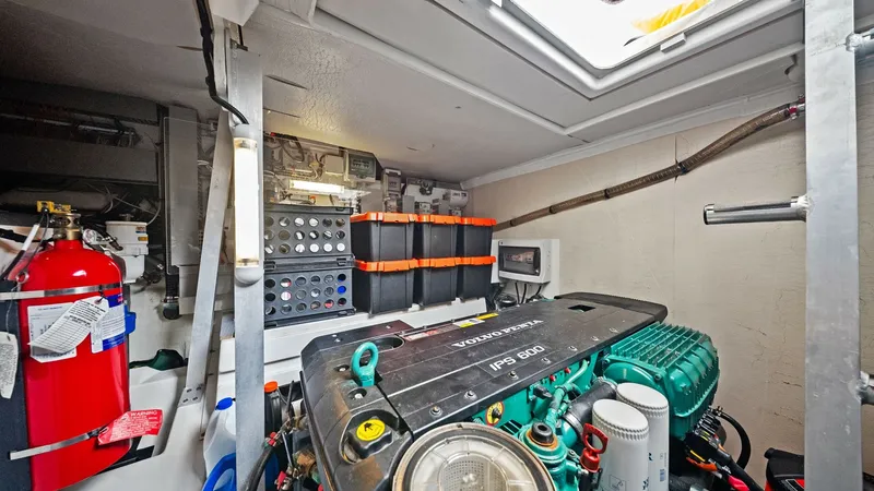 Slide: The Image of Engine Room with Volvo Penta Motor The engine room of the Prestige 500 Fly showcases a powerful Volvo Penta motor, known for its reliability and performance. The organized layout features easy access to essential components, including a well-secured fire extinguisher for safety. The space - 7603821