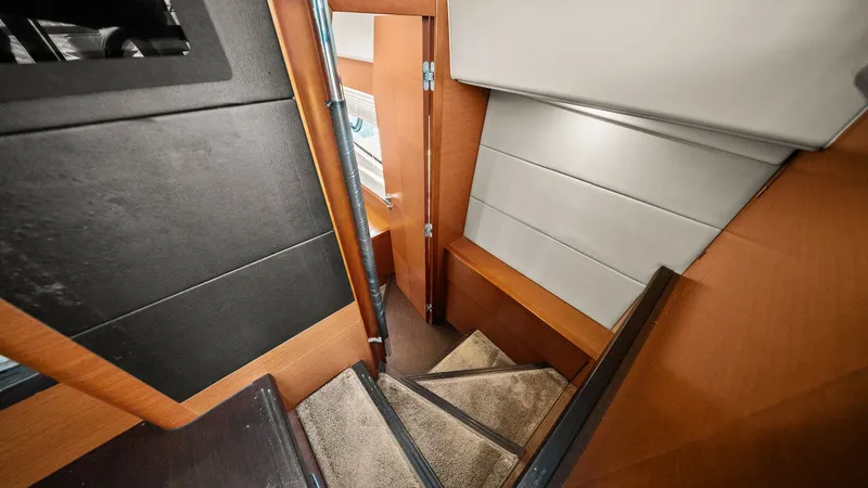 Slide: The Image of Interior Staircase to Lower Deck This image showcases the elegant staircase leading to the lower deck of the Prestige 500 Fly. The warm wood finishes and sleek design create a welcoming transition between levels. Thoughtfully integrated handrails ensure safety and enhance the modern aest - 7603807