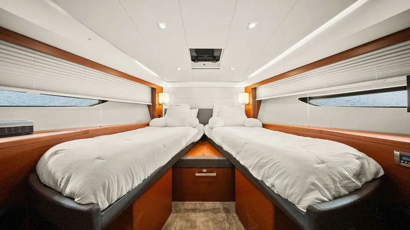 Slide: The Image of Twin Guest Cabin This inviting twin guest cabin on the 2015 Prestige 500 Fly offers a serene retreat with its plush, side-by-side beds. The space is enhanced by rich wood finishes and ample natural light from the side windows. Elegant overhead lighting and a central drawe - 7603808