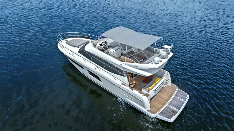 Slide: The Image of Flybridge and Aft Deck View This image showcases the expansive flybridge and aft deck of the 2015 Prestige 500 Fly. The flybridge is equipped with comfortable seating and a retractable canopy, offering an ideal space for relaxation and panoramic views. The spacious aft deck features - 7603836