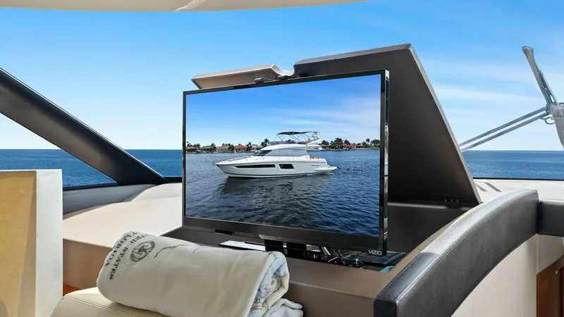 Slide: The Image of Salon with Pop-Up TV The salon of the Prestige 500 Fly boasts a sleek pop-up TV feature, providing entertainment with a stunning view of the sea through expansive windows. The luxurious leather seating and polished wood accents create an inviting and comfortable interior spac - 7603795