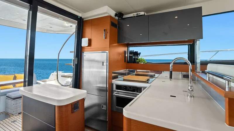 Slide: The Image of Modern Galley with Ocean View The galley of the 2015 Prestige 500 Fly offers a sleek and functional space with modern appliances and elegant finishes. Featuring expansive countertops and high-quality cabinetry, this area is both practical and stylish. Large windows provide stunning oc - 7603776