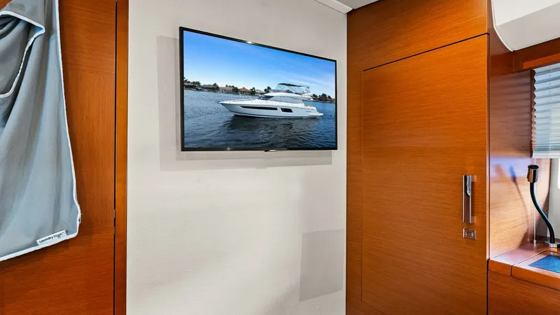 Slide: The Image of Guest Cabin with TV and Wood Finish This inviting guest cabin on the 2015 Prestige 500 Fly features warm wood paneling that adds a touch of elegance. A flat-screen TV is mounted on the wall, providing entertainment options for guests. The space is thoughtfully designed for comfort and funct - 7603816