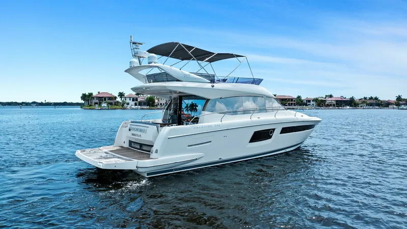 Slide: The Image of Aft View with Flybridge This image showcases the sleek aft design of the Prestige 500 Fly, highlighting its spacious swim platform and elegant flybridge. The yacht's streamlined profile is complemented by large windows that enhance natural light and provide panoramic views. The - 7603829