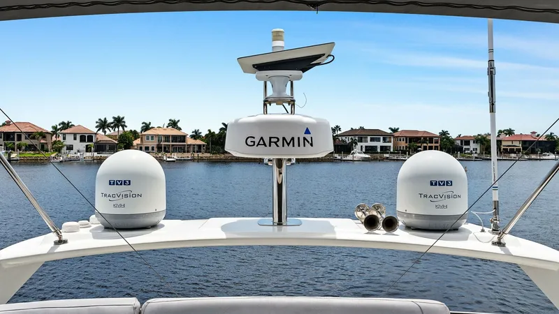 Slide: The Image of Flybridge Electronics and View The flybridge of the 2015 Prestige 500 Fly showcases advanced navigation equipment, including twin TracVision domes and a Garmin radar. This setup ensures seamless connectivity and precise navigation. The spacious layout offers unobstructed views of the s - 7603766