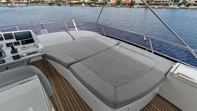 Slide: The Image of Flybridge Sunpad Lounge The flybridge of the Prestige 500 Fly features a spacious sunpad lounge, perfect for relaxation while enjoying panoramic views. The plush, gray cushions offer comfort and style, set against the backdrop of elegant teak decking. Adjacent to the helm, this - 7603765