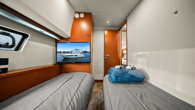 Slide: The Image of Twin Guest Cabin with TV This inviting twin guest cabin on the 2015 Prestige 500 Fly features two comfortable single beds and elegant wood finishes. A mounted flat-screen TV offers entertainment, while the cleverly integrated lighting enhances the cozy ambiance. The cabin provide - 7603815
