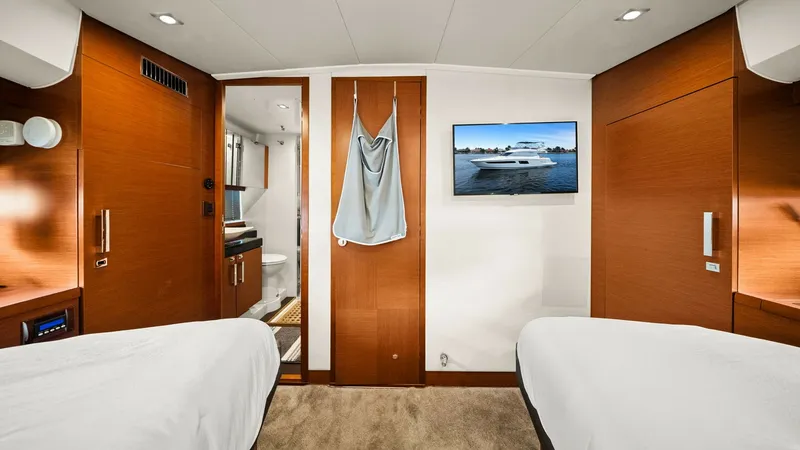 Slide: The Image of Twin Guest Cabin with Ensuite This inviting twin guest cabin on the Prestige 500 Fly features two comfortable beds and warm wood finishes, creating a cozy retreat. The cabin includes an ensuite bathroom with modern fixtures, enhancing privacy and convenience for guests. A wall-mounted - 7603810