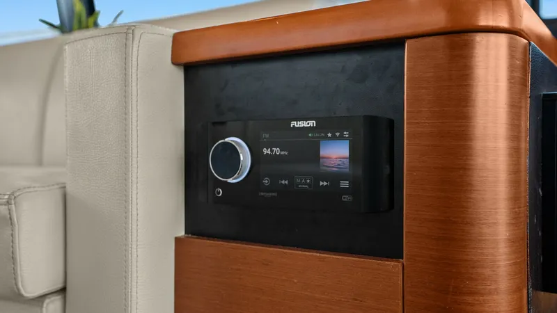 Slide: The Image of Entertainment Console with Fusion Stereo This image showcases the elegant entertainment console aboard the 2015 Prestige 500 Fly, featuring a sleek Fusion stereo system. The console is crafted with rich wooden finishes, adding a touch of luxury to the interior. The modern design seamlessly integ - 7603786