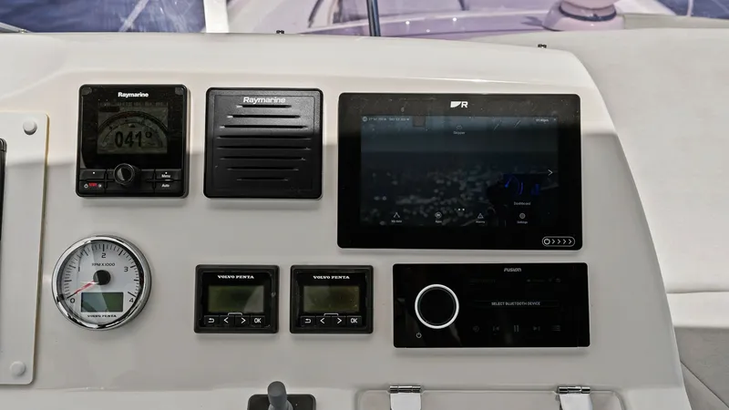 Slide: The Image of Flybridge Helm Station Controls The helm station on the Prestige 500 Fly showcases a modern control panel equipped with advanced Raymarine navigation systems and Volvo Penta engine monitors. The sleek dashboard design ensures all controls are within easy reach, enhancing maneuverability - 7603761
