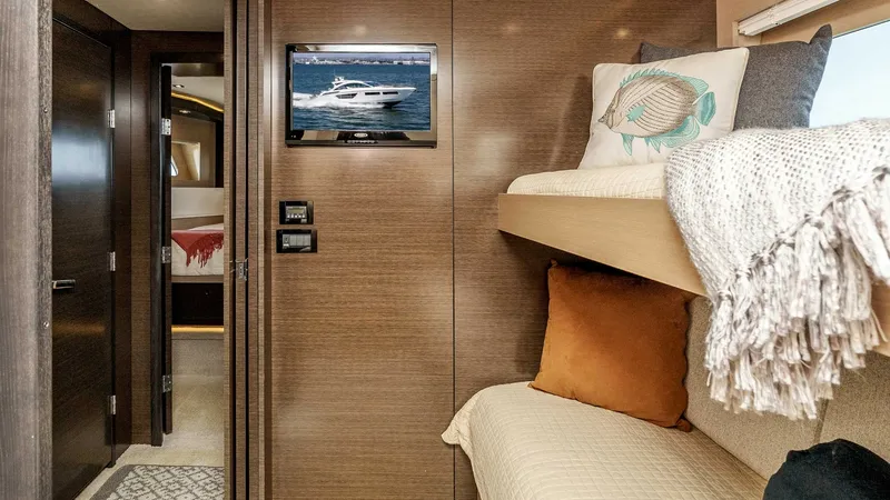 Slide: The Image of 2017 Cruisers 60 Cantius 'Rising Star' - Guest Cabin with Bunk Beds This cozy guest cabin features stylish bunk beds, providing comfortable accommodations for additional guests. The warm wood paneling and soft textiles create a welcoming atmosphere, while a mounted television offers entertainment options. Thoughtful desig - 7603866