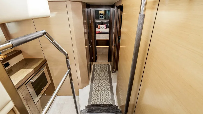 Slide: The Image of 2017 Cruisers 60 Cantius 'Rising Star' - Lower Deck Corridor The 2017 Cruisers 60' Cantius showcases the elegant lower-deck Accommodation passageway. Warm wood paneling, rich dark-wood trim, and polished stainless-steel accents create a refined, contemporary atmosphere. The staircase is thoughtfully designed with s - 7603853