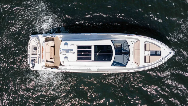 Slide: The Image of Aerial View of 2017 Cruisers 60 Cantius "Rising Star" This aerial shot captures the sleek design of the 2017 Cruisers 60 Cantius, highlighting its spacious deck layout. The vessel features an elegant sunroof and ample seating on the aft deck, perfect for relaxation and entertainment. The clean lines and mode - 7603882