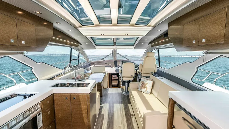 Slide: The Image of 2017 Cruisers 60 Cantius 'Rising Star' - Spacious Interior Salon with Helm The interior salon of the 2017 Cruisers 60 Cantius offers a luxurious and open space accentuated by panoramic windows and a skylight. High-end finishes and modern cabinetry create a sophisticated ambiance, while the comfortable seating area provides an in - 7603842