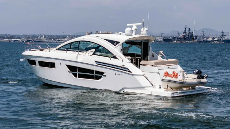 Slide: The Image of 2017 Cruisers 60 Cantius, 'Rising Star' - Port-Aft View with Swim Platform and Tender Storage. The 2017 Cruisers 60 Cantius, 'Rising Star,' showcases a sleek starboard aft view, highlighting its modern lines and expansive windows. The spacious swim platform offers easy access to the water and features a stylish tender for added versatility. The ves - 7603887