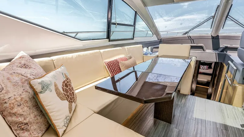 Slide: The Image of 2017 Cruisers 60 Cantius 'Rising Star' - Spacious Salon with Panoramic Views The salon of the 2017 Cruisers 60 Cantius 'Rising Star' features expansive windows that flood the space with natural light, offering panoramic views of the surrounding waters. Plush seating with decorative cushions provides comfort, while the elegant dini - 7603847