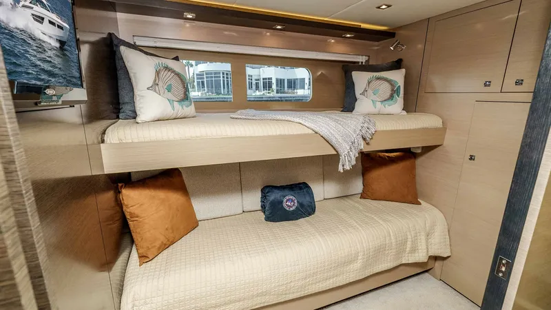 Slide: The Image of 2017 Cruisers 60 Cantius 'Rising Star' - Guest Bunk Cabin; Lower Berth Converts to Double Berth. This guest stateroom on the 2017 Cruisers 60 Cantius features cozy bunk beds with the lower berth converting to a double bed, making this setup ideal for additional guests. The room is elegantly finished with light wood cabinetry and soft, inviting textil - 7603865