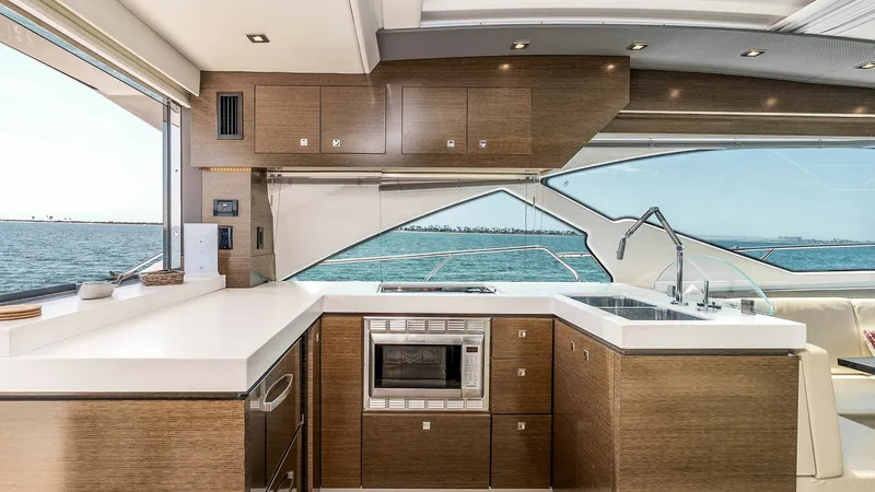 Slide: The Image of 2017 Cruisers 60 Cantius 'Rising Star' - Modern Galley with Ocean View The galley of the 2017 Cruisers 60 Cantius offers a sleek and functional space, featuring high-quality wood cabinetry and modern appliances. Expansive windows provide a stunning ocean view, enhancing the open and airy ambiance. The well-designed layout in - 7603844