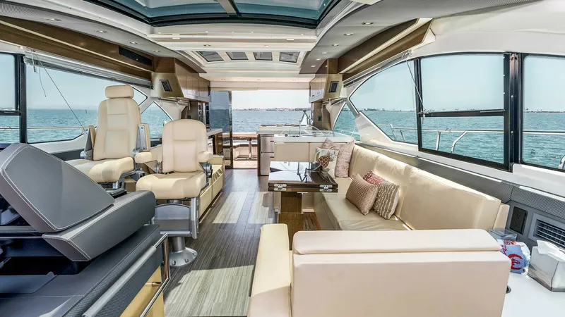 Slide: The Image of 2017 Cruisers 60 Cantius 'Rising Star' - Spacious Interior Salon with Helm The interior salon of the 2017 Cruisers 60 Cantius 'Rising Star' offers a luxurious blend of comfort and style with its plush seating and panoramic windows. The helm station features state-of-the-art controls, while the skylight and sleek wood finishes cr - 7603852