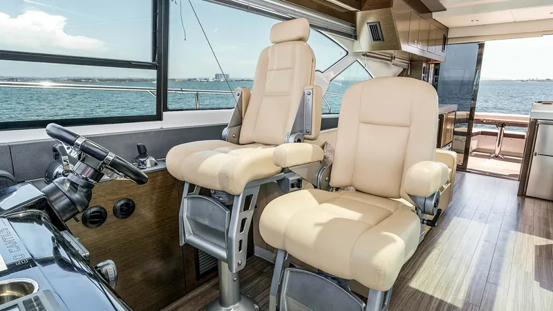 Slide: The Image of 2017 Cruisers 60 Cantius 'Rising Star' - Helm Station with Dual Seating The helm station of the 2017 Cruisers 60 Cantius features elegant dual captain's chairs upholstered in plush cream leather, offering comfort and style. The panoramic windows provide excellent visibility, enhancing the navigation experience. The sleek desi - 7603850