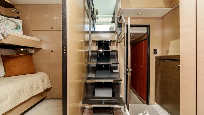 Slide: The Image of 2017 Cruisers 60 Cantius 'Rising Star' - Salon Stairway to Master, Bunk Cabin & Laundry This image showcases the sleek and modern interior stairway of the 2017 Cruisers 60 Cantius, leading to the upper deck. The warm wood finishes and soft lighting create an inviting atmosphere, complemented by the cozy cabin with plush bedding. This design - 7603855