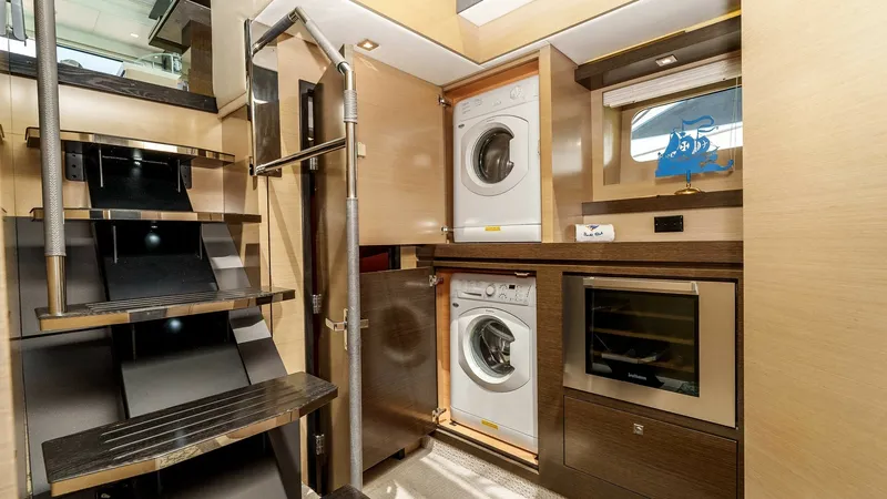 Slide: The Image of 2017 Cruisers 60 Cantius 'Rising Star' - Utility Area with Laundry Appliances This functional utility area on the 2017 Cruisers 60 Cantius features stacked washer and dryer units, offering convenient laundry solutions. The space is designed with sleek cabinetry and modern finishes, ensuring practicality without sacrificing style. A - 7603854