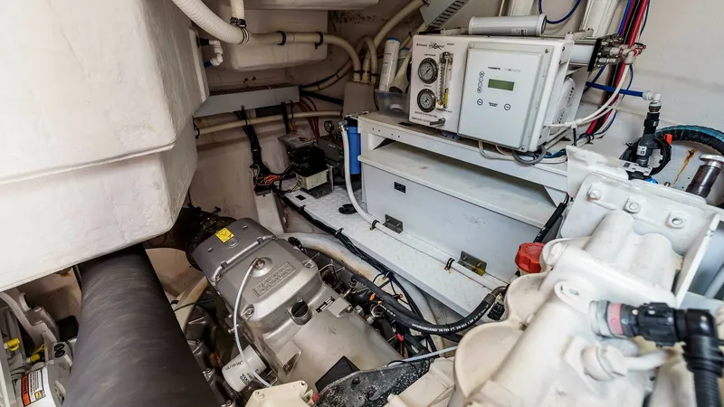 Slide: The Image of 2017 Cruisers 60 Cantius, 'Rising Star' - Engine Room with Mechanical & Water System Components. The engine room of the 2017 Cruisers 60 Cantius features meticulously arranged mechanical systems and components. Visible are the advanced filtration systems and control panels, highlighting the vessel's modern engineering. The clean layout ensures easy a - 7603870