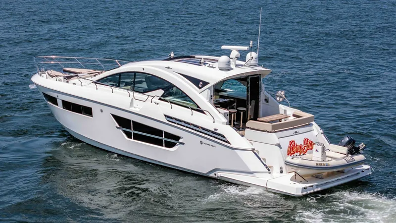 Slide: The Image of 2017 Cruisers 60 Cantius, 'Rising Star' - Port-Aft Deck and Stern View The 2017 Cruisers 60 Cantius 'Rising Star' showcases a sleek and modern aft deck with ample seating for relaxation. The spacious design includes a hydraulic swim platform, enhancing accessibility to the water. The clean lines and contemporary styling refl - 7603888