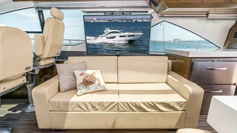Slide: The Image of 2017 Cruisers 60 Cantius 'Rising Star' - Salon Seating with Panoramic Views The salon of the 2017 Cruisers 60 Cantius, 'Rising Star', offers plush seating with a beige leather sofa, providing comfort and style. Large windows allow for expansive ocean views, enhancing the bright and airy atmosphere. Modern finishes and a flat-scre - 7603848