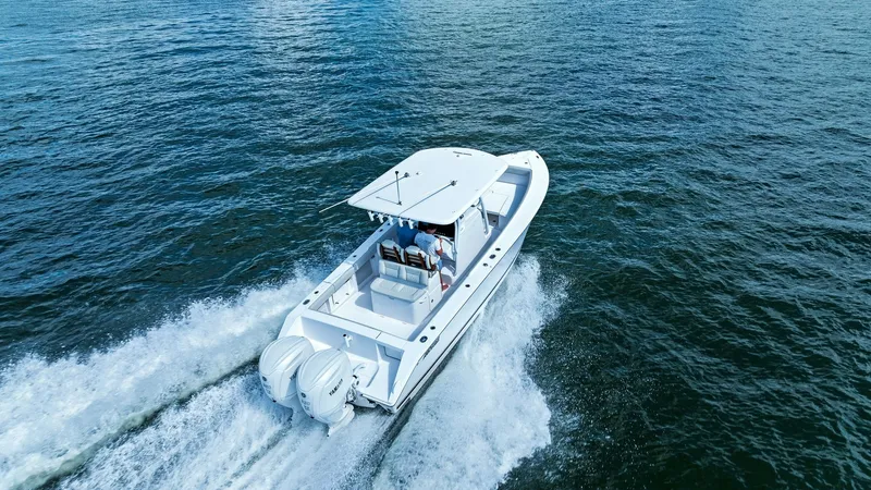 Slide: The Image of Aerial View of Spacious Aft Deck The Jupiter 30 HFS showcases a sleek and powerful design with its spacious aft deck, perfect for both fishing and leisure activities. The dual outboard engines provide impressive speed and performance, while the T-top offers shade and protection. This mod - 7718754