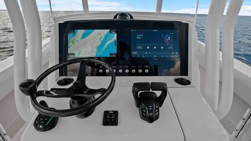 Slide: The Image of State-of-the-Art Helm Station The helm station of the 2025 Jupiter 30 HFS features dual multifunction displays, offering seamless navigation and entertainment control. The sleek, ergonomic design includes a modern steering wheel and advanced throttle controls for precise maneuvering. - 7718738
