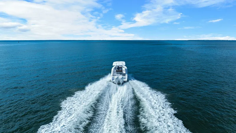 Slide: The Image of Aerial View of Jupiter 30 HFS The 2025 Jupiter 30 HFS is captured from an aerial perspective, showcasing its powerful twin engines cutting through the serene blue waters. The boat's sleek design and robust wake highlight its exceptional performance and handling. Ideal for both leisure - 7718748
