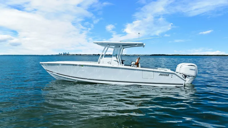 Slide: The Image of Starboard Profile of Jupiter 30 HFS The 2025 Jupiter 30 HFS showcases a sleek starboard profile against a serene ocean backdrop. Its modern, clean lines and robust hull are complemented by a stylish T-top, offering both functionality and aesthetic appeal. Powered by twin Yamaha outboards, t - 7718743