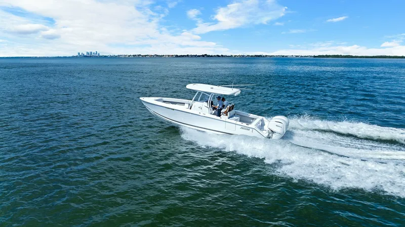 Slide: The Image of Aerial View of Jupiter 30 HFS in Motion The 2025 Jupiter 30 HFS is captured gliding effortlessly across open waters, showcasing its sleek design and powerful outboard engines. The center console layout provides ample space for navigation and comfort, ideal for both fishing and leisure cruising. - 7718750