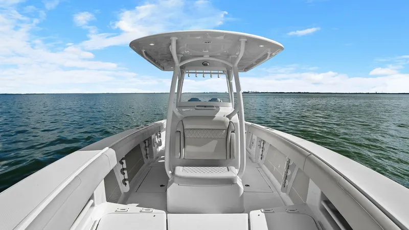 Slide: The Image of Center Console and Bow Seating The 2025 Jupiter 30 HFS showcases a spacious center console with sleek, ergonomic seating at the bow. The clean lines and ample walk-around space provide an inviting area for relaxation and socializing. The sturdy T-top offers shade and protection, enhanc - 7718732