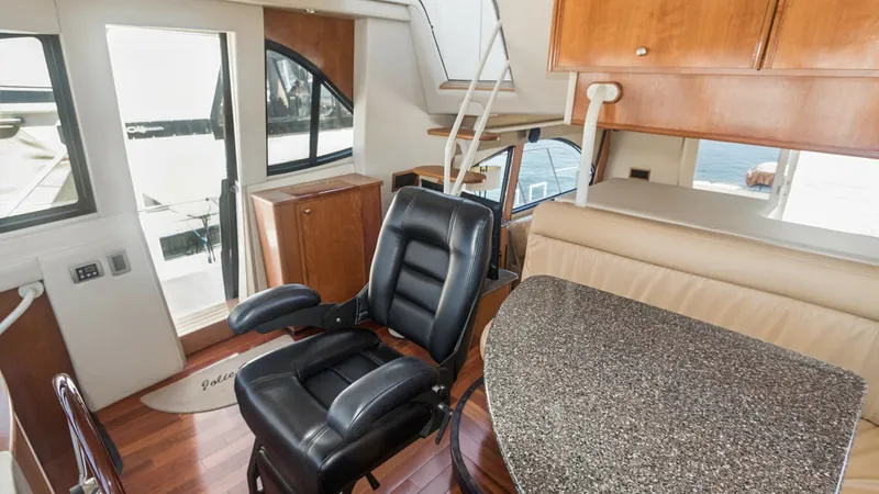Slide: The Image of Pilothouse with Command Chair The pilothouse of the 2005 Meridian 540 Pilothouse features a plush, ergonomic command chair that ensures comfort during navigation. The space is elegantly designed with high-gloss wood finishes and a granite-like countertop, providing both functionality - 7721597