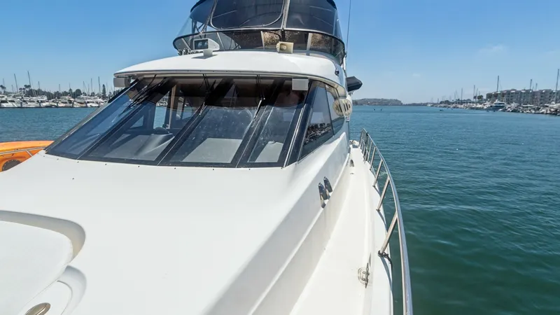 Slide: The Image of Forward Deck and Flybridge View This image showcases the sleek forward deck of the 2005 Meridian 540 Pilothouse 'JOLIE VIE'. The expansive view highlights the modern, aerodynamic design, complemented by large windows that provide ample natural light to the interior. The flybridge above - 7721620