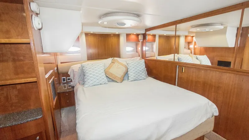 Slide: The Image of Master Stateroom with Queen Bed The master stateroom of the 2005 Meridian 540 Pilothouse 'JOLIE VIE' features a comfortable queen-size bed, highlighted by rich wood paneling and elegant built-in cabinetry. The room benefits from ample natural light through side windows, creating a warm - 7721603