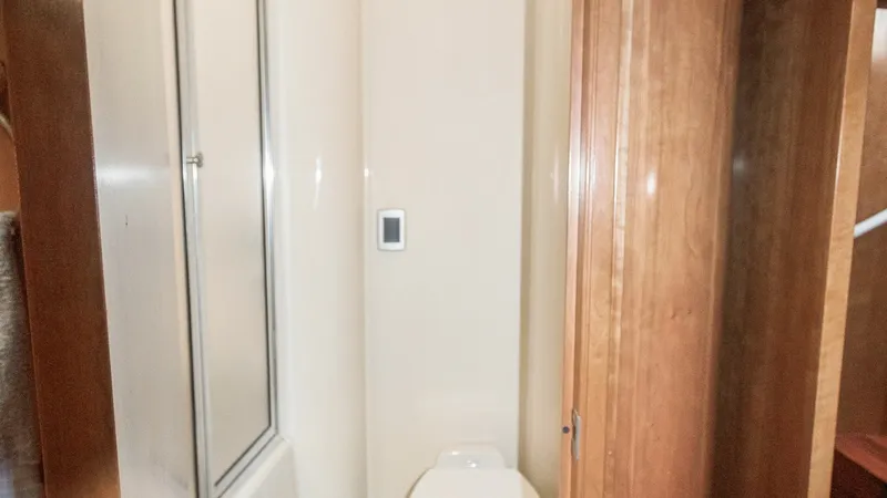 Slide: The Image of Compact Yacht Bathroom This cozy bathroom on the 2005 Meridian 540 Pilothouse features a sleek design with a modern toilet and enclosed shower. The space maximizes functionality with its efficient layout and high-quality finishes. Wood accents add warmth, complementing the vess - 7721605