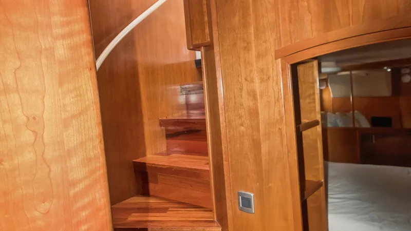 Slide: The Image of Elegant Wooden Staircase and Cabin Entrance This image showcases a beautifully crafted wooden staircase leading to the upper deck of the Meridian 540 Pilothouse. The rich wood finish exudes warmth and luxury, complementing the vessel's elegant interior design. Adjacent to the staircase is a glimpse - 7721613