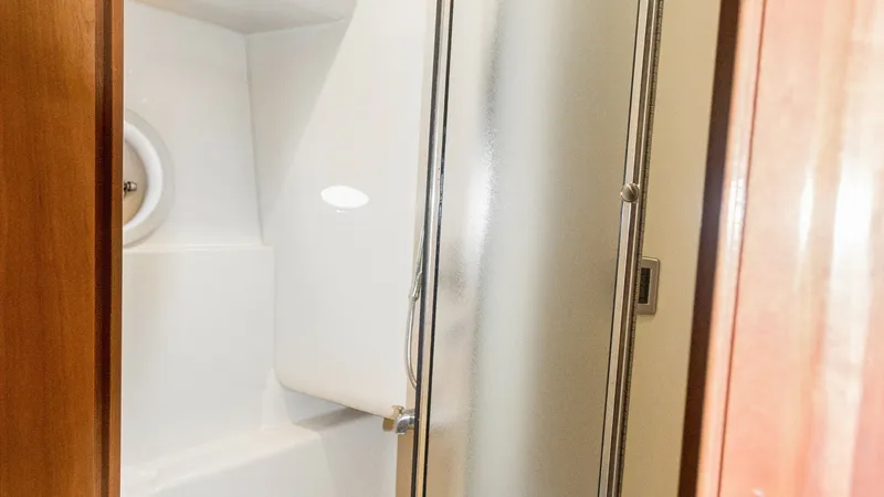 Slide: The Image of Enclosed Shower in Guest Head The enclosed shower features a frosted glass door and sleek white fixtures, providing a modern and clean aesthetic. Thoughtfully designed with efficient use of space, it offers comfort and privacy. The bright lighting and quality materials make this an in - 7721604