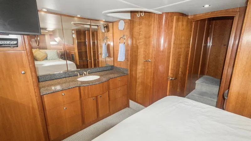Slide: The Image of Master Stateroom with Vanity The master stateroom of the 2005 Meridian 540 Pilothouse features elegant wood finishes and a spacious layout. A sleek vanity with a granite countertop and ample storage is complemented by a mounted TV for entertainment. The room's design is both function - 7721606
