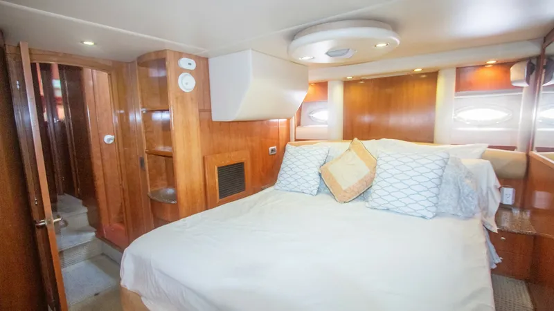 Slide: The Image of Master Stateroom with Queen Bed The master stateroom of the 2005 Meridian 540 Pilothouse features a plush queen-sized bed, accented with elegant pillows and soft lighting. Rich wood paneling and cabinetry provide ample storage and add a touch of luxury. Large windows allow natural light - 7721602