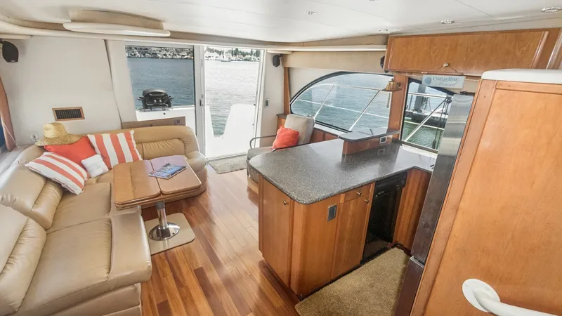 Slide: The Image of Main Salon with Galley View The main salon of the 2005 Meridian 540 Pilothouse offers a luxurious and inviting space with plush L-shaped seating and a stylish wooden table, perfect for entertaining. The open layout seamlessly connects to a well-equipped galley featuring sleek counte - 7721600