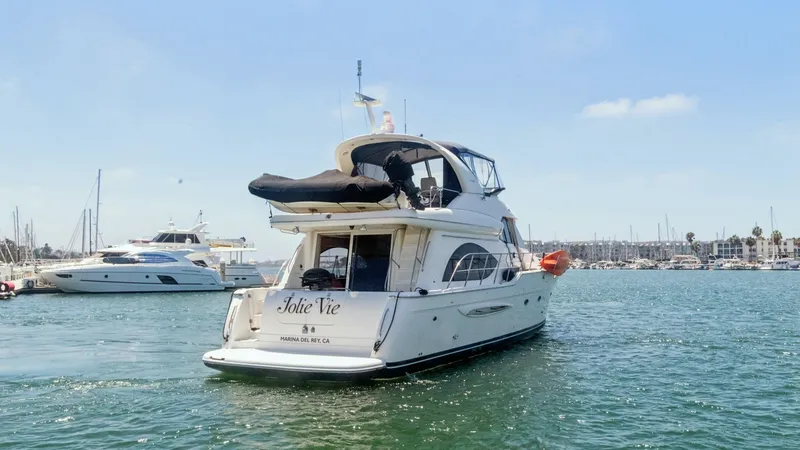 Slide: The Image of Aft View with Upper Deck The image showcases the aft view of the 2005 Meridian 540 Pilothouse, 'Jolie Vie', gracefully navigating through the marina. The spacious upper deck is equipped with a canopy, offering ample space for relaxation and enjoying panoramic views. The sleek des - 7721628